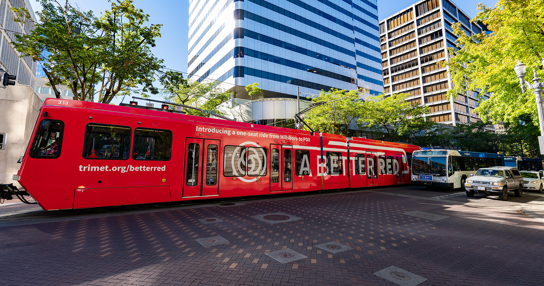 MAX in downtown Portland with 'A Better Red' vehicle wrap on the side