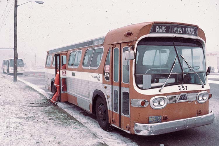 Operator putting traction chains on a TriMet bus in ice storm