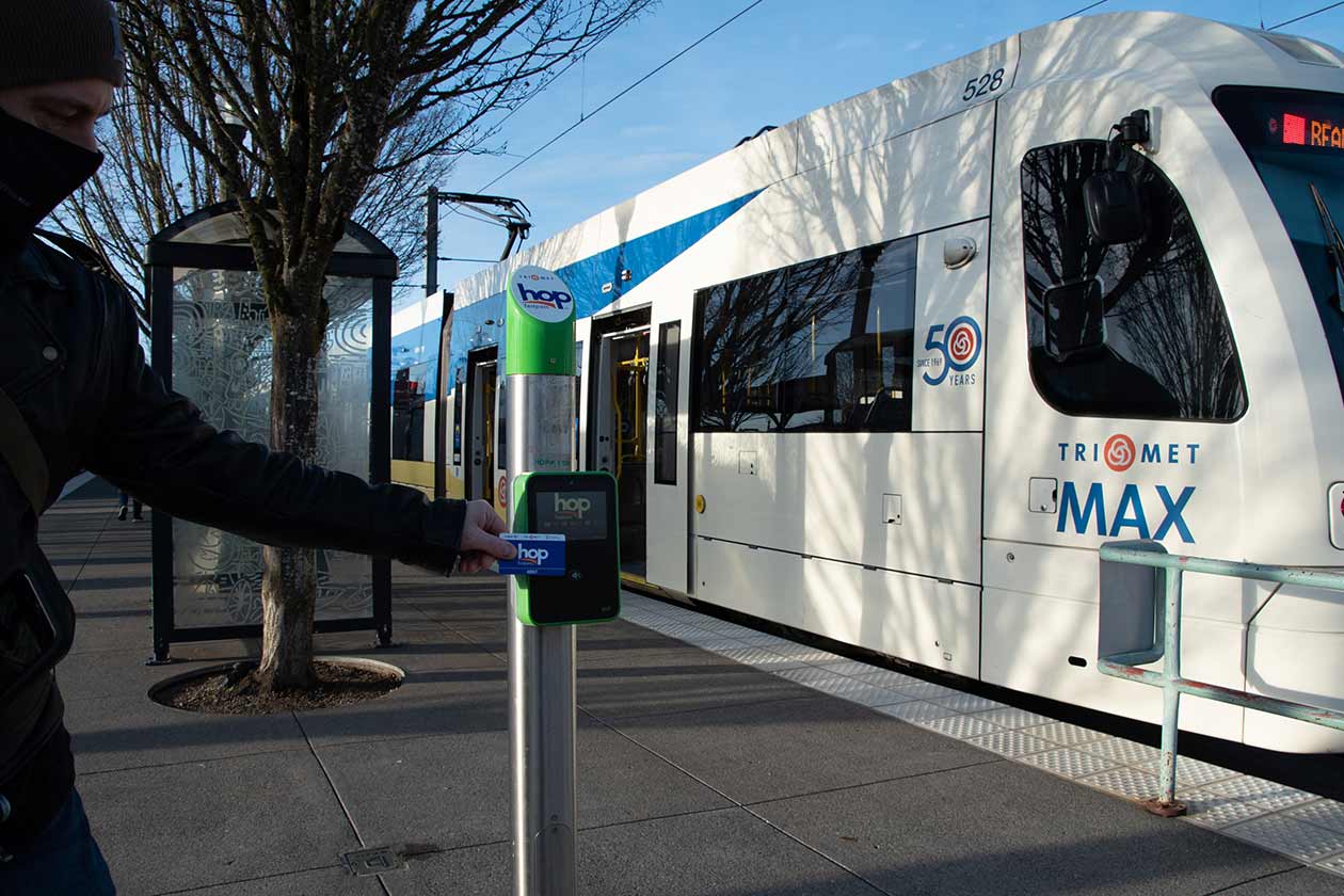 Rider tapping Hop reader on MAX platform